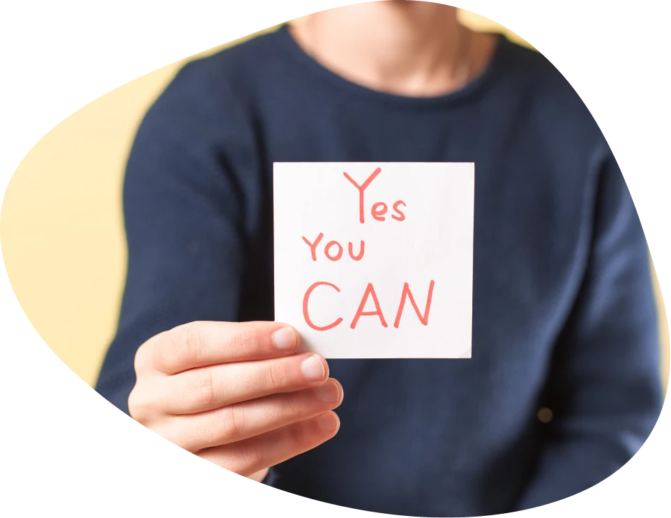 person holding a paper that says yes you can